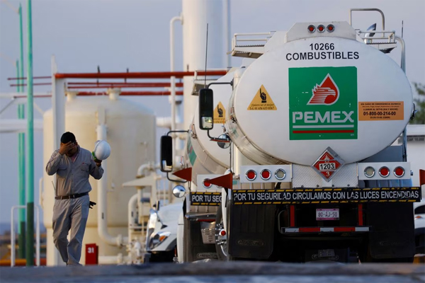 Un trabajador camina cerca de un camión cisterna en un centro de almacenamiento y distribución de combustible de Petróleos Mexicanos (PEMEX) en Ciudad Juárez, México 14 de junio de 2022.