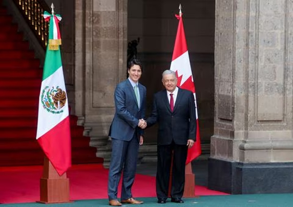 El primer ministro de Canadá, Justin Trudeau, y el presidente de México, Andrés Manuel López Obrador, saludan mientras asisten a una ceremonia oficial de bienvenida durante la Cumbre de Líderes de América del Norte en el Palacio Nacional en Ciudad de México, México, 11 de enero de 2023.  