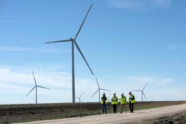 Empleados de Engie caminan por una carretera para observar las turbinas eólicas durante un recorrido por la inauguración del Proyecto Eólico Limestone en Dawson, Texas, el 28 de febrero de 2023 