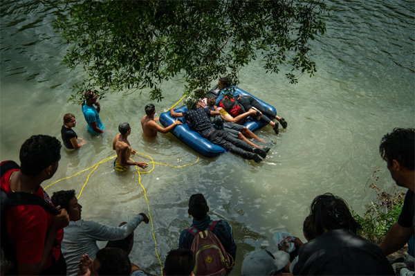 Un grupo de migrantes cruzando el río Bravo entre Matamoros, México, y Brownsville, Texas, el miércoles. Muchos dijeron que estaban tratando de cruzar antes de que el Título 42 expirara el jueves por la noche. (Meridith Kohut para The New York Times)