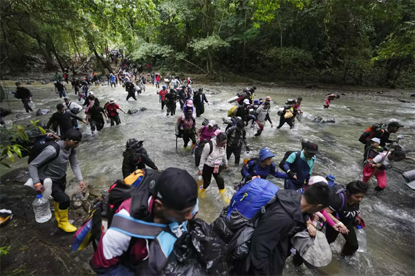 Migrantes, en su mayoría venezolanos, cruzan un río en la selva del Darién el 15 de octubre de 2022, en un recorrido de Colombia a Panamá, con la esperanza de seguir luego su viaje hacia Estados Unidos. La Agencia de la ONU para los Refugiados (ACNUR) y la Organización Internacional para las Migraciones (OIM) indicaron en un comunicado el jueves 13 de abril de 2023 que más 100.000 migrantes cruzaron esa ruta en los primeros meses del año y que, de seguir la tendencia, la cifra a final del año podría superar los 400.000. (AP Foto/Fernando Vergara, Archivo)
(Fernando Vergara / Associated Press)