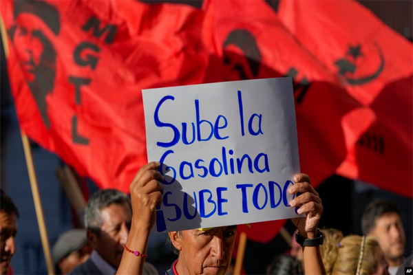 Un manifestante sostiene un cartel durante una protesta antigubernamental contra el aumento de los precios del combustible, en Quito, Ecuador, el 12 de junio de 2024.