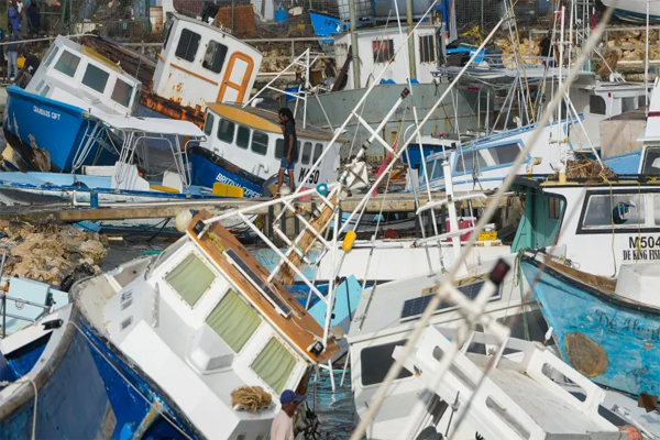 Un pescador observa los barcos pesqueros dañados por el huracán Beryl en los caladeros de Bridgetown, en Barbados, el lunes 1 de julio de 2024. (AP Photo/Ricardo Mazalan)