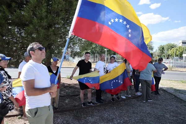 Partidarios sostienen banderas venezolanas a la llegada del candidato presidencial de la oposición venezolana por el partido Plataforma Unitaria Democrática, Edmundo González Urrutia, al aeropuerto militar de Torrejón de Ardoz en Madrid el 8 de septiembre de 2024. 