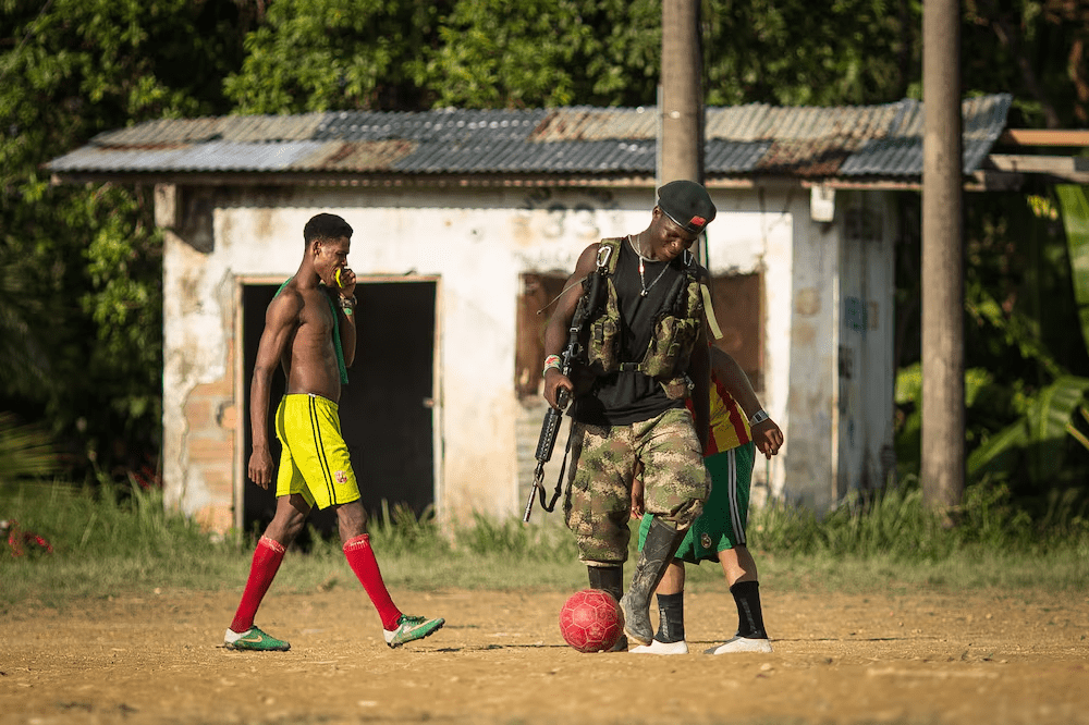 ast Of The Cold Warriors, ELN Guerrillas Are Oiling Their WeaponsFoto de archivo de 2017 que muestra a un guerrillero del ELN jugando fútbol con residentes locales en una aldea remota(Fotógrafo: Ivan Valencia/Bloomb/Ivan Valencia)