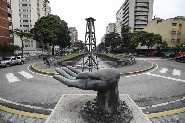 A sculpture of a hand holding an oil well outside Venezuela’s state oil company PDVSA