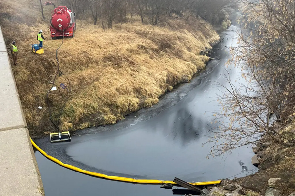 Workers deployed a boom on the surface of Mill Creek, in Washington County, Kan., on Thursday to contain oil that leaked from the Keystone pipeline system.