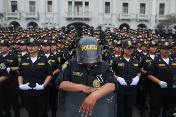 Police officers stand in formation during a protest march in Lima on Friday. 