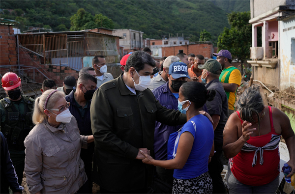 Venezuela’s President Nicolas Maduro, center visits an area damaged during floods in Las Tejerias, Venezuela, on Oct. 10.