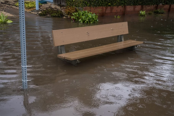 A bus stop bench submerged in floodwaters in Aptos, California, US, on Wednesday. Jan. 11, 2023. California faces more drenching rain as a historic drought has given way to flooding that’s killed at least 17 people, closed highways and sent residents fleeing for their lives. 