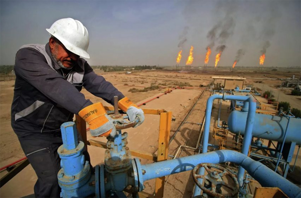 A technician controlling a valve in an oil facility in Iraq.  