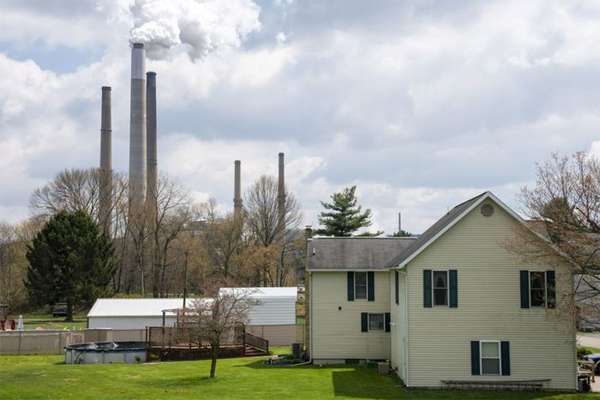 A home stands in front of the Conesville Power Plant in Conesville, Ohio, April 18, 2020. Mercury, arsenic and other toxic metals are released into the air from power-plant smokestacks.