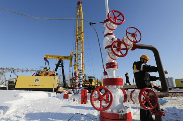 A worker collects a sample of crude from a well in Russia’s Samotlor oil field.