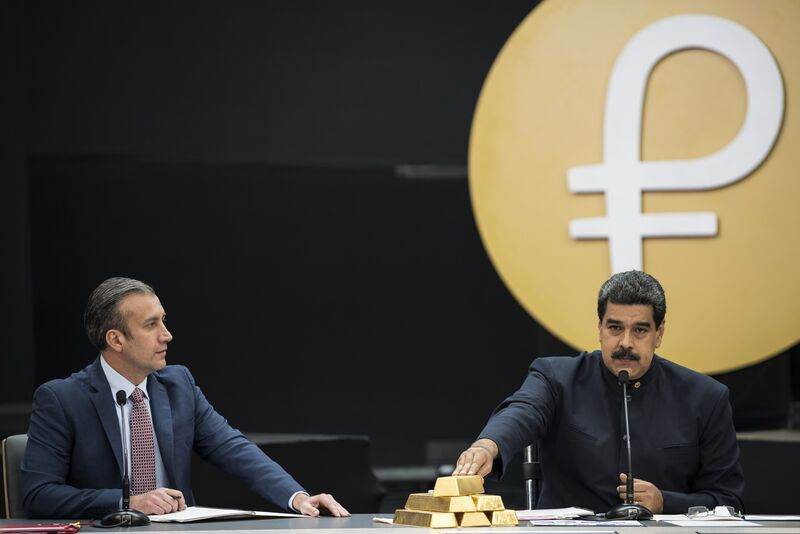 Nicolas Maduro, right, speaks as he touches a stack of 12 Kilogram gold ingots during a news conference on the country’s cryptocurrency in 2018. 