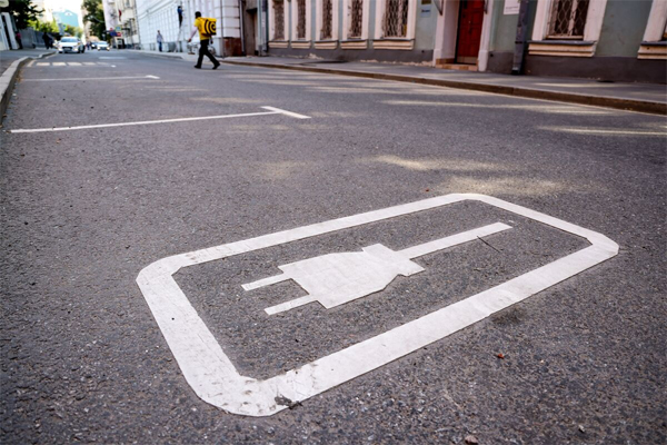 An electric vehicle charging point logo on the ground.