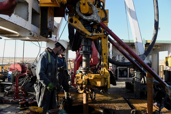 A drilling crew prepares to make a new pipe connection on a lease owned by Elevation Resources near Midland, Texas