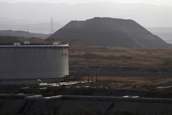 A mound of coke is seen next to an oil tank at PDVSA's Jose Antonio Anzoategui industrial complex in the state of Anzoategui April 15, 2015.  