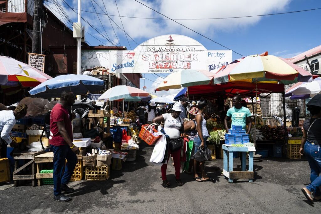 Shoppers walk past vendors at the Stabroek Market in Georgetown, Guyana.Photographer: Eilon Paz/Bloomberg