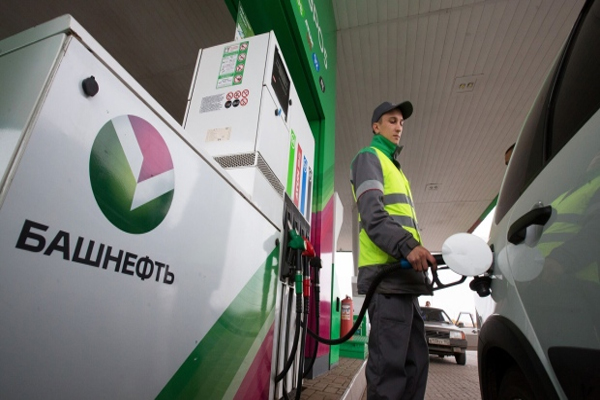 A worker fuels an automobile using a hand pump at a gas station operated by Bashneft PAO in Ufa, Russia, on Wednesday, Sept. 28, 2016. Bashneft distributes petroleum products and petrochemicals around the world and in Russia via filling stations. Photographer: Andrey Rudakov/Bloomberg ,  