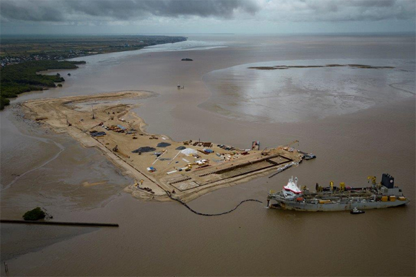 A ship creates an artificial island by extracting offshore sand to create a coastal port for offshore oil production at the mouth of the Demerara River in Georgetown, Guyana, Wednesday, April 12, 2023. Guyana is poised to become the world’s fourth-largest offshore oil producer, placing it ahead of Qatar, the United States, Mexico and Norway. (AP Photo/Matias Delacroix)