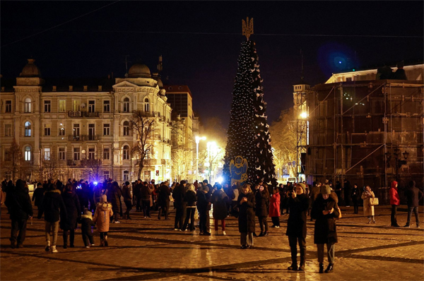 People gather next to a Christmas tree to celebrate the New Year eve before a curfew, amid Russia's attack on Ukraine, in front of the St. Sophia Cathedral in Kyiv, Ukraine, Dec. 31, 2022. (Reuters Photo)