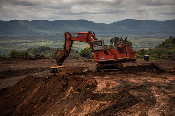 An excavator moves earth to a dump truck on the open mining site of Venezuelan iron ore producer, CVG Ferrominera Orinoco, on Bolivar Hill outside of Ciudad Piar, Venezuela, on Thursday, July 9, 2015.Photographer: Meridith Kohut/Bloomberg