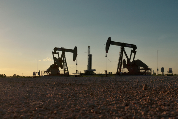 Pump jacks operate in front of a drilling rig in an oil field in Midland, Texas U.S. August 22, 2018. Picture taken August 22, 2018. REUTERS/Nick Oxford