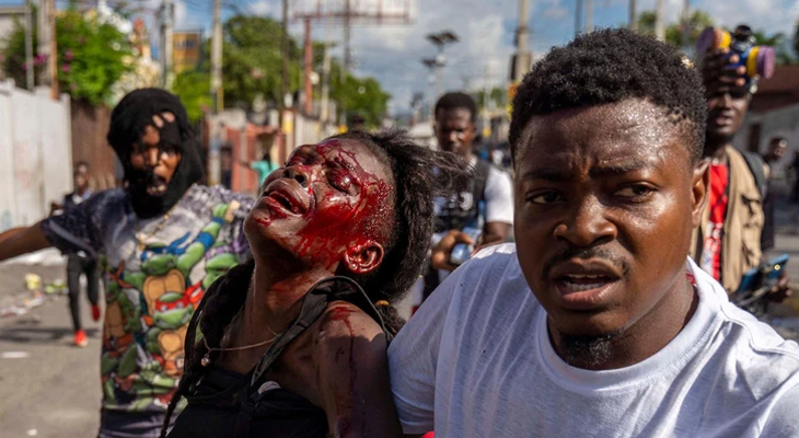 A man assists an injured woman during a protest demanding the resignation of Haitian Prime Minister Ariel Henry in Port-au-Prince, Haiti on October 10, 2022. (Photo: Richard Pierrin/AFP via Getty Images)