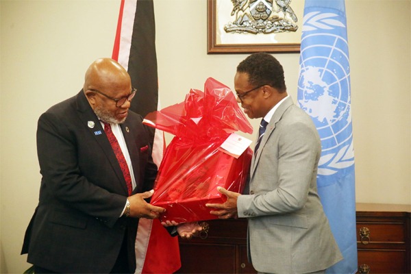  Minister of Foreign and Caricom Affairs Dr Amery Browne, right, presents a gift to UN General Assembly president Dennis Francis during the latter’s visit to the ministry’s St Clair office yesterday.