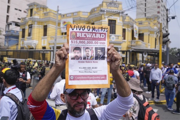 Venezuelan Tulio Rodriguez holds a wanted sign of Venezuelan President Nicolas Maduro that reads in Spanish: “Reward. Dead or alive” outside the Venezuelan embassy in Lima, Peru, Thursday, Jan. 9, 2025, the day before his inauguration for a third term. (AP Photo/Martin Mejia)